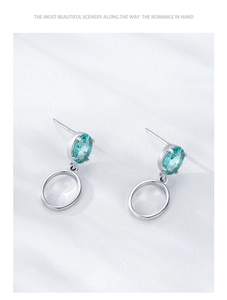 Détail de boucles d'oreilles S925 en argent avec pierre ovale Paraiba et pendentif rond