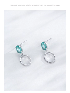 Detail of S925 sterling silver earrings with mint green gemstone and hollow metal pendant