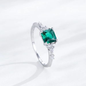 Elegante anello in argento S925 con smeraldo quadrato e diamanti sui lati della fascia