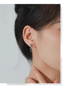 Close-up of S925 sterling silver earring with green oval gemstone on model's ear
