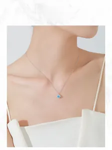 Détail du collier en argent massif S925 avec pierre carrée bleu clair portée par le modèle