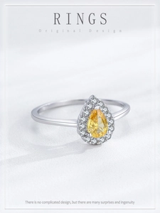 Macro shot of S925 sterling silver ring with pear-cut yellow stone and halo setting
