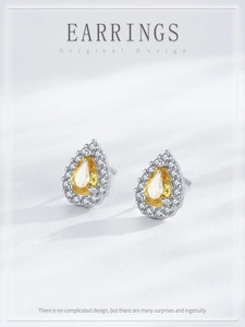 Gros plan de boucles d'oreilles en argent S925 avec cristal jaune taille poire