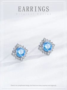 Detail of S925 silver sunflower earrings with light blue gemstone and zircon cluster