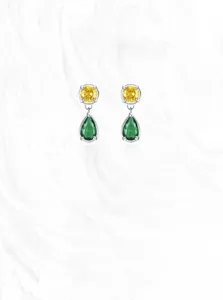 Detailed view of silver drop earrings with round yellow and pear-shaped green zircons