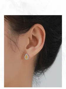 Détail de boucle d'oreille goutte en zircon jaune sur modèle avec monture argentée chic