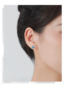 Gros plan sur les boucles d'oreilles tournesol en argent S925 avec saphir et zircon