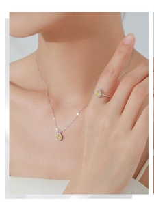 Detail of pear-cut yellow diamond jewelry set with silver necklace and ring on model