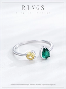 Detail of adjustable silver ring with round yellow zircon and pear-cut green gemstone