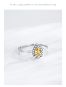 Macro shot of S925 silver ring featuring a pear-cut yellow gemstone with halo setting