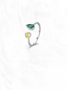 Detailed macro shot of S925 sterling silver ring with green and yellow pear-cut zirconia