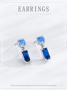 Detail view of S925 silver earrings with round light blue and square dark blue stones