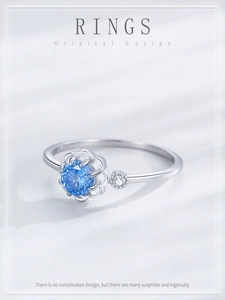 Detailed macro view of S925 silver flower ring with a brilliant blue gemstone setting