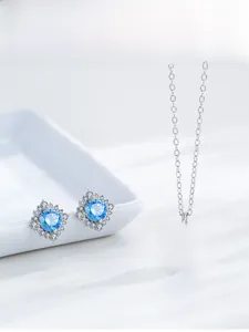 Halo design jewelry set with light blue round gemstones and silver necklace and earrings