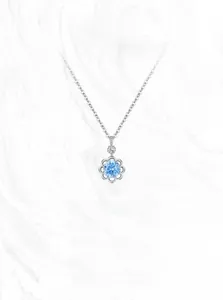 Détail d'un pendentif fleur en argent S925 orné d'une pierre précieuse bleu ciel
