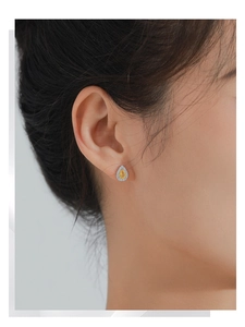 Vue macro de boucles d'oreilles gouttes en argent avec zircon jaune et pavé blanc