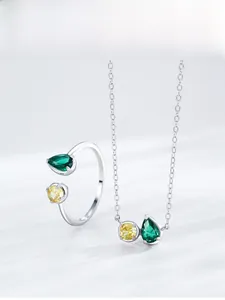 Détail de la parure en argent avec collier et bague aux pierres vertes et jaunes