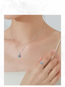 Close-up of S925 silver jewelry set with light blue flower pendant necklace and ring