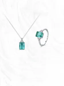 Macro detail of S925 sterling silver ring and necklace set with emerald cut green gemstones
