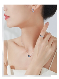 Gros plan d'un ensemble de bijoux en argent S925 avec zircons bleus sur un mannequin