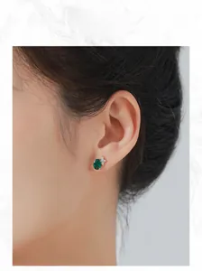 Modèle portant des boucles d'oreilles ovales en émeraude et zircon en argent S925