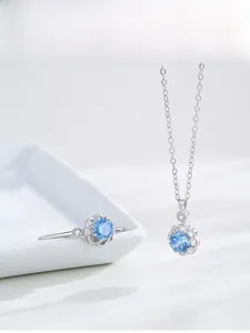 Gros plan d'un ensemble collier et bague en argent S925 avec pierres bleues