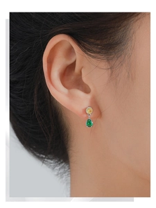 Detail of S925 silver earrings with round yellow and pear-shaped green sapphire stones