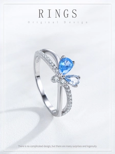 Close-up of S925 silver butterfly ring with blue drop stones and zircon pavé wings