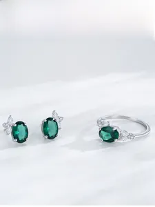 Détail macro d'une boucle d'oreille en argent S925 avec zircon émeraude et forme papillon