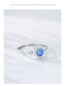 Close-up of S925 sterling silver flower ring featuring a sea blue gem and side diamond