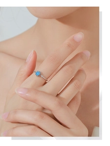 Detail of silver S925 ring featuring blue opal flower petals and small diamonds