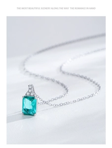 Close-up of S925 sterling silver necklace with emerald cut green gemstone and diamonds