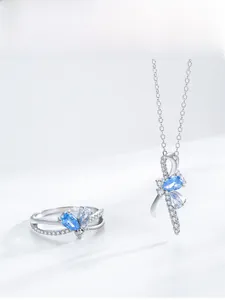Close-up of S925 silver bow ring and necklace set with light blue pear-cut zircons