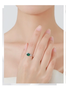 Nahaufnahme eines eleganten S925 Silberrings mit ovalem Smaragd und seitlichen Zirkonia-Akzenten