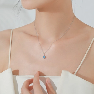 Collier en argent S925 avec pendentif fleur bleue porté par un mannequin sous lumière