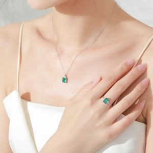 Elegant S925 sterling silver jewelry set featuring emerald-cut green gemstones on model