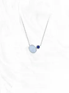 Close-up of minimalist S925 silver necklace with oval white opal and blue stone pendants