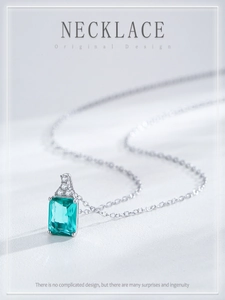 Macro detail of S925 silver necklace with emerald-cut light blue stone and small diamonds