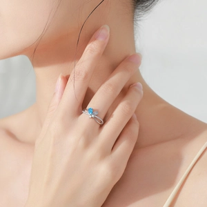 S925 sterling silver bow ring featuring blue pear-cut zircon on female hand model