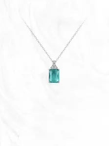 Detailed shot of emerald cut light blue crystal pendant with pave set diamonds on silver chain