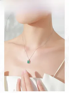 Elegant model wearing a S925 silver necklace with rectangular green gemstone pendant