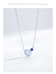 Macro detail of S925 silver necklace with oval opal and round blue sapphire pendant