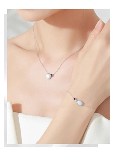 Detailed close-up of S925 silver oval opal pendant necklace and bracelet set on model