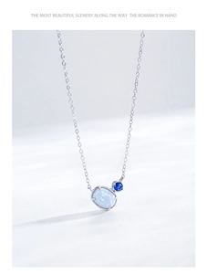 Detailed shot of S925 silver necklace with oval opal pendant and small blue zircon