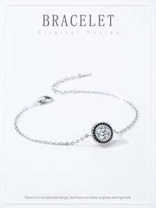 Macro detail of S925 silver bracelet featuring a central zircon and black stone halo