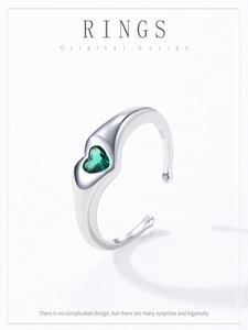 Macro shot of S925 sterling silver ring showing heart-shaped green zircon and engraved logo