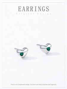 Close-up of S925 sterling silver heart studs with sparkling green zircon inlays
