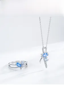 Detailed view of silver bow jewelry set with blue teardrop stones and white zircon crystals