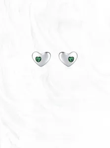 Detailed macro view of S925 sterling silver heart earrings with green gemstone inlay