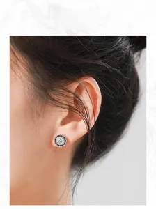 Close-up of S925 sterling silver halo stud earrings with a large white zircon and black gems